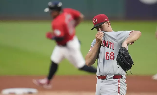 Cincinnati Reds pitcher Carson Spiers (68) wipes his face as Cleveland Guardians' Josh Naylor, left, runs around second base on a home run ball hit by Lane Thomas in the first inning of a baseball game in Cleveland, Tuesday, Sept. 24, 2024. (AP Photo/Sue Ogrocki)