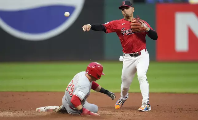 Cleveland Guardians second baseman Andres Gimenez, right, forces out Cincinnati Reds' TJ Friedl, left, at second base and completes the throw for the out on Ty France for a double play in the second inning of a baseball game in Cleveland, Tuesday, Sept. 24, 2024. (AP Photo/Sue Ogrocki)