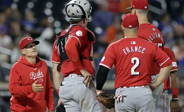 Cincinnati Reds manager David Bell reaches for the ball from pitcher Brandon Williamson during a pitching change in the sixth inning of a baseball game against the New York Mets, Friday, Sept. 6, 2024, in New York. (AP Photo/Adam Hunger)