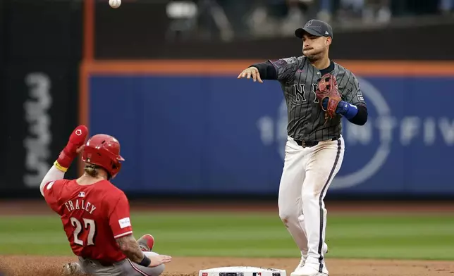 New York Mets second baseman Jose Iglesias gets the force out on Cincinnati Reds' Jake Fraley (27) and turns the double play on Jonathan India during the third inning of a baseball game Saturday, Sept. 7, 2024, in New York. (AP Photo/Adam Hunger)