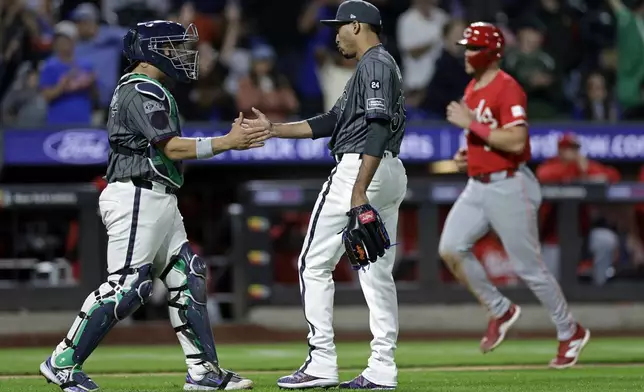 New York Mets pitcher Edwin Diaz and catcher Francisco Alvarez celebrate as Cincinnati Reds' Tyler Stephenson runs in the background after the Mets won 4-0 in a baseball game Saturday, Sept. 7, 2024, in New York. AP Photo/Adam Hunger)