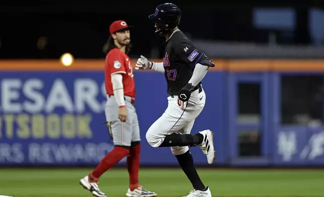 New York Mets' Mark Vientos (27) rounds the bases past Cincinnati Reds second baseman Jonathan India, left, after hitting a two-run home run during the first inning of a baseball game Friday, Sept. 6, 2024, in New York. (AP Photo/Adam Hunger)