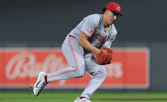 Cincinnati Reds starting pitcher Julian Aguiar fields the ball during the third inning of a baseball game against the Minnesota Twins, Friday, Sept. 13, 2024, in Minneapolis. (AP Photo/Nikolas Liepins)