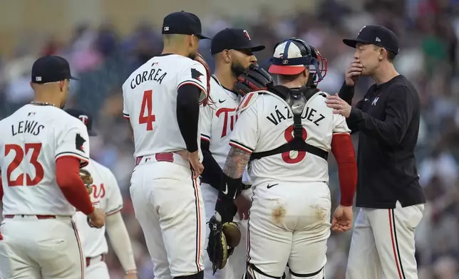 Minnesota Twins starting pitcher Simeon Woods Richardson, back center, talks with teammates and pitching coach Pete Maki, right, during the third inning of a baseball game against the Cincinnati Reds, Saturday, Sept. 14, 2024, in Minneapolis. (AP Photo/Abbie Parr)