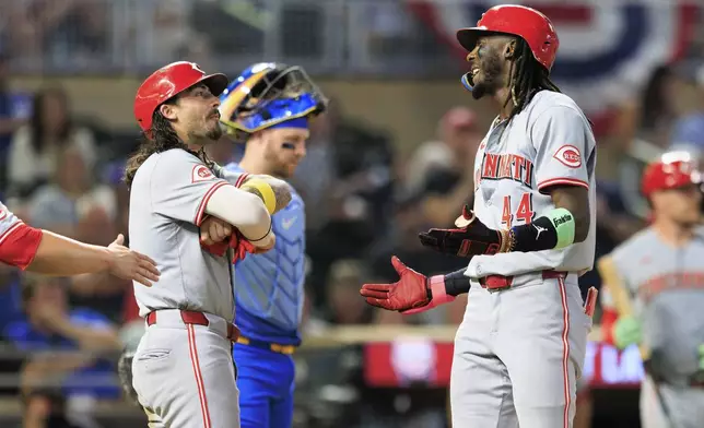 Cincinnati Reds Elly De La Cruz (44) celebrates with teammates after hitting a grand slam during the seventh inning of a baseball game against the Minnesota Twins, Friday, Sept. 13, 2024, in Minneapolis. (AP Photo/Nikolas Liepins)