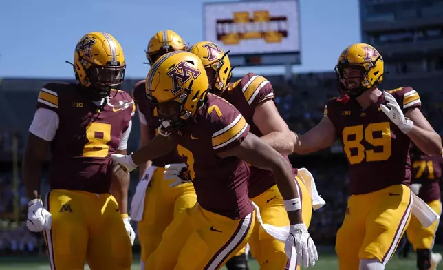 Minnesota wide receiver Tyler Williams (7), front, celebrates with teammates after scoring an 8-yard touchdown against Rhode Island during the second half of an NCAA college football game Saturday, Sept. 7, 2024, in Minneapolis. (AP Photo/Abbie Parr)