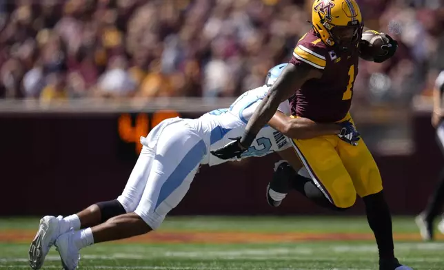 Minnesota running back Darius Taylor (1) runs with the football as Rhode Island defensive back Andre DePina-Gray (30) tries to tackle during the second half of an NCAA college football game Saturday, Sept. 7, 2024, in Minneapolis. (AP Photo/Abbie Parr)