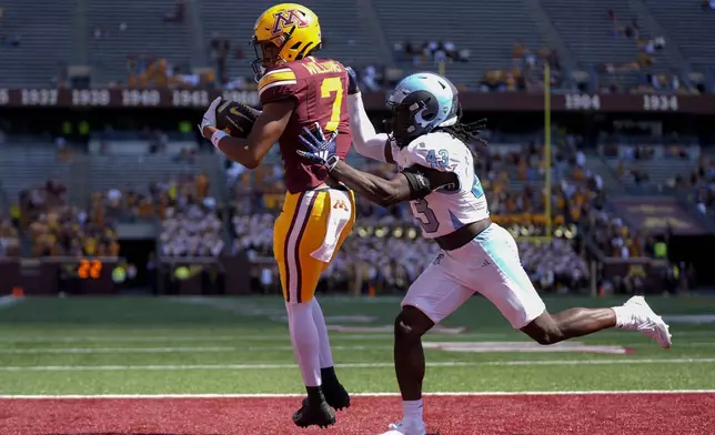 Minnesota wide receiver Tyler Williams (7) scores an 8-yard touchdown as Rhode Island defensive back Seun Filaoye (43) tries to defend during the second half of an NCAA college football game Saturday, Sept. 7, 2024, in Minneapolis. (AP Photo/Abbie Parr)