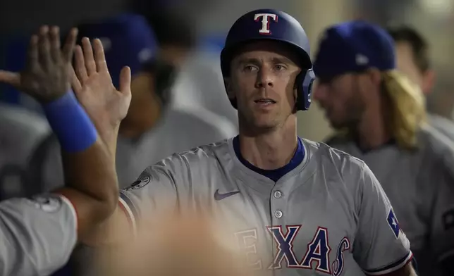 Texas Rangers' Matt Duffy celebrates in the dugout after scoring off of a double by Nathaniel Lowe during the eighth inning of a baseball game against the Los Angeles Angels in Anaheim, Calif., Saturday, Sept. 28, 2024. (AP Photo/Ashley Landis)