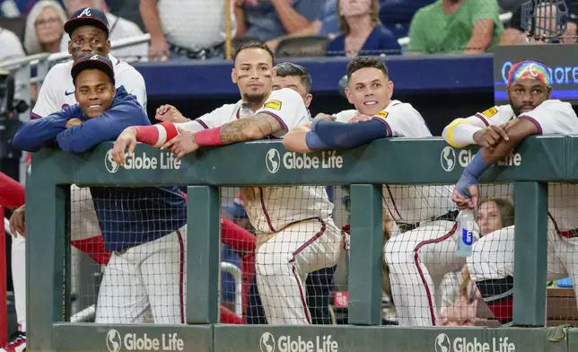 Atlanta Braves outfielder Jorge Soler, far left, pitcher Raisel Iglesias, left with blue sweatshirt, shortstop Orlando Arcia center left, third baseman Gio Urshela, center right, and outfielder Michael Harris II, right, watch Marcell Ozuna (20) at bat in the ninth inning of a baseball game against the Colorado Rockies, Thursday, Sept. 5, 2024, in Atlanta. (AP Photo/Jason Allen)