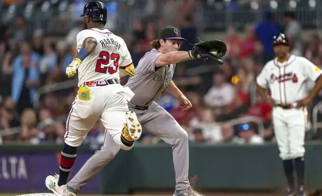 Colorado Rockies first baseman Michael Toglia, center, catches the throw as Atlanta Braves' Michael Harris II (23) is forced out at first base in the fifth inning of a baseball game, Thursday, Sept. 5, 2024, in Atlanta. (AP Photo/Jason Allen)