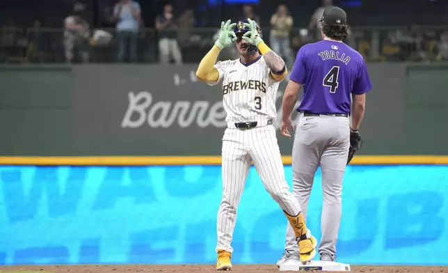 Milwaukee Brewers' Joey Ortiz (3) celebrates after hitting an RBI double as Colorado Rockies first baseman Michael Toglia (4) covers second base during the fourth inning of a baseball game Saturday, Sept. 7, 2024, in Milwaukee. (AP Photo/Kayla Wolf)