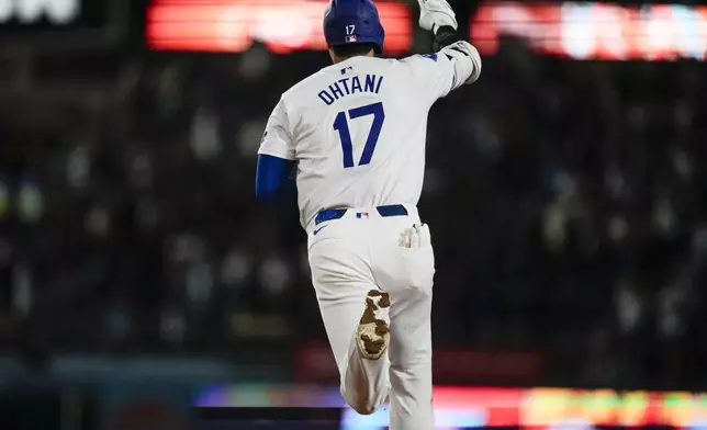 Los Angeles Dodgers designated hitter Shohei Ohtani (17) runs the bases after hitting a home run during the fifth inning of a baseball game against the Colorado Rockies in Los Angeles, Friday, Sept. 20, 2024. Max Muncy also scored. (AP Photo/Ashley Landis)