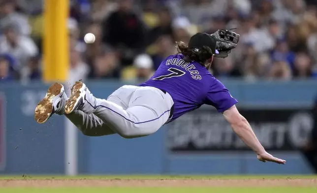 Colorado Rockies second baseman Brendan Rodgers can't get to a ball hit for an RBI single by Los Angeles Dodgers' Hunter Feduccia during the fourth inning of a baseball game, Saturday, Sept. 21, 2024, in Los Angeles. (AP Photo/Mark J. Terrill)