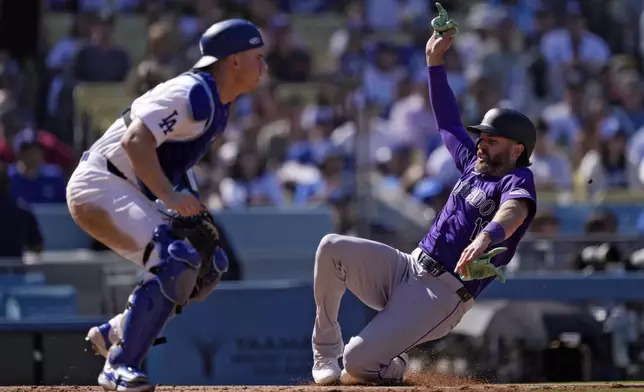 Colorado Rockies' Jake Cave, right, scores on a double by Hunter Goodman as Los Angeles Dodgers catcher Will Smith waits for the ball during the sixth inning of a baseball game, Sunday, Sept. 22, 2024, in Los Angeles. (AP Photo/Mark J. Terrill)