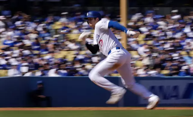 Los Angeles Dodgers' Shohei Ohtani heads to third as Freddie Freeman grounds into a double play to end the third inning of a baseball game against the Colorado Rockies, Sunday, Sept. 22, 2024, in Los Angeles. (AP Photo/Mark J. Terrill)