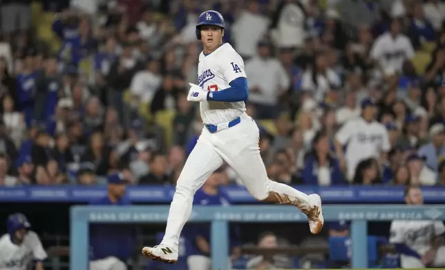 Los Angeles Dodgers designated hitter Shohei Ohtani (17) scores off of a single by Teoscar Hernández during the seventh inning of a baseball game against the Colorado Rockies in Los Angeles, Friday, Sept. 20, 2024. (AP Photo/Ashley Landis)