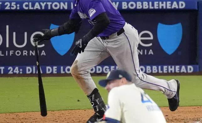 Colorado Rockies' Charlie Blackmon, top, heads to first for a two-run home run as Los Angeles Dodgers relief pitcher Daniel Hudson, left, watches during the ninth inning of a baseball game, Saturday, Sept. 21, 2024, in Los Angeles. (AP Photo/Mark J. Terrill)