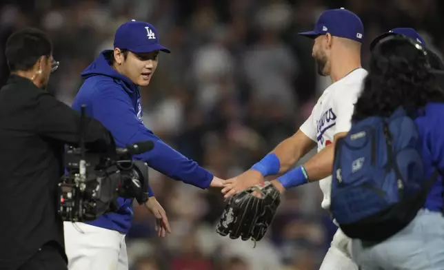 Los Angeles Dodgers designated hitter Shohei Ohtani celebrates with outfielder Kevin Kiermaier, right, after a 6-4 win over the Colorado Rockies in a baseball game in Los Angeles, Friday, Sept. 20, 2024. (AP Photo/Ashley Landis)