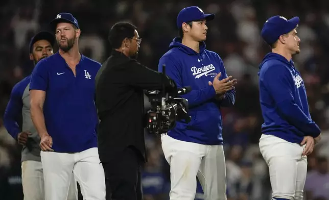 Los Angeles Dodgers designated hitter Shohei Ohtani, second from right, celebrates after a 6-4 win over the Colorado Rockies in a baseball game in Los Angeles, Friday, Sept. 20, 2024. (AP Photo/Ashley Landis)