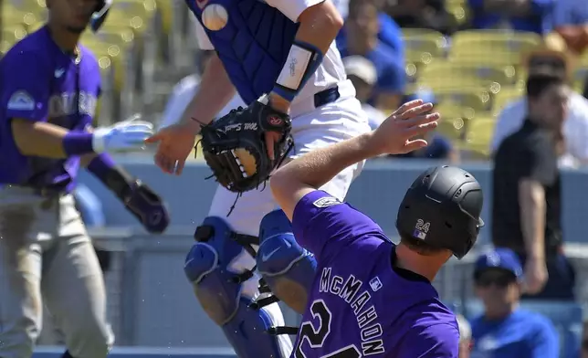 Colorado Rockies' Ryan McMahon, right, scores on a single by Brendan Rodgers as Los Angeles Dodgers catcher Will Smith takes a late throw during the first inning of a baseball game, Sunday, Sept. 22, 2024, in Los Angeles. (AP Photo/Mark J. Terrill)