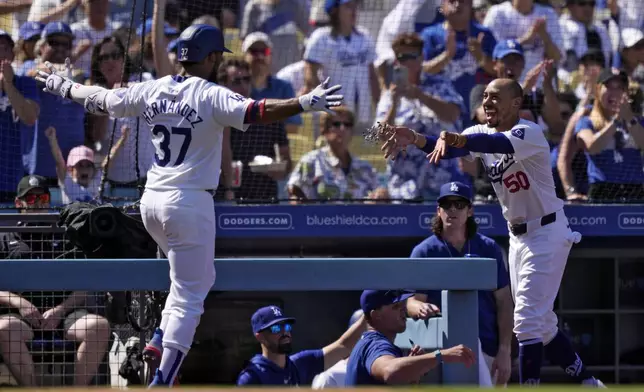 Los Angeles Dodgers' Teoscar Hernández, left, has sunflower seeds thrown at him by Mookie Betts after hitting a solo home run during the fourth inning of a baseball game against the Colorado Rockies, Sunday, Sept. 22, 2024, in Los Angeles. (AP Photo/Mark J. Terrill)