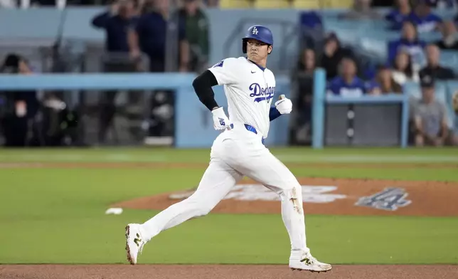 Los Angeles Dodgers' Shohei Ohtani rounds second as Mookie Betts flies out during the third inning of a baseball game against the Colorado Rockies, Friday, Sept. 20, 2024, in Los Angeles. (AP Photo/Mark J. Terrill)