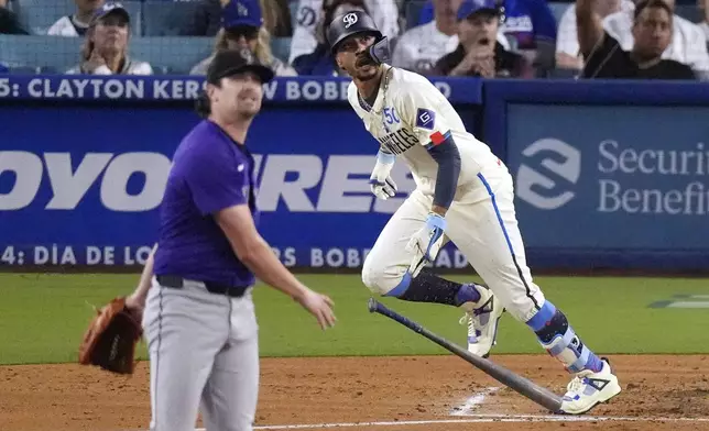 Los Angeles Dodgers' Mookie Betts, right, heads to first for a two-run home run as Colorado Rockies starting pitcher Cal Quantrill watches during the third inning of a baseball game, Saturday, Sept. 21, 2024, in Los Angeles. (AP Photo/Mark J. Terrill)