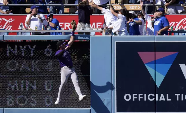 Colorado Rockies left fielder Nolan Jones can't reach a ball hit by Los Angeles Dodgers' Kiké Hernández for a two-run home run during the seventh inning of a baseball game, Sunday, Sept. 22, 2024, in Los Angeles. (AP Photo/Mark J. Terrill)