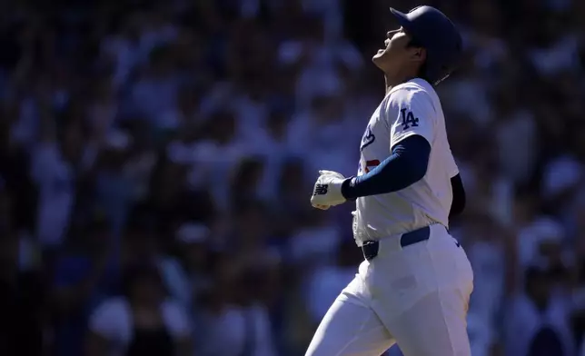 Los Angeles Dodgers' Shohei Ohtani scores on a single by Freddie Freeman during the seventh inning of a baseball game against the Colorado Rockies, Sunday, Sept. 22, 2024, in Los Angeles. (AP Photo/Mark J. Terrill)