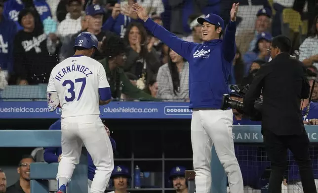 Los Angeles Dodgers' Teoscar Hernández (37) celebrates with designated hitter Shohei Ohtani after hitting a home run during the sixth inning of a baseball game against the Colorado Rockies in Los Angeles, Friday, Sept. 20, 2024. (AP Photo/Ashley Landis)