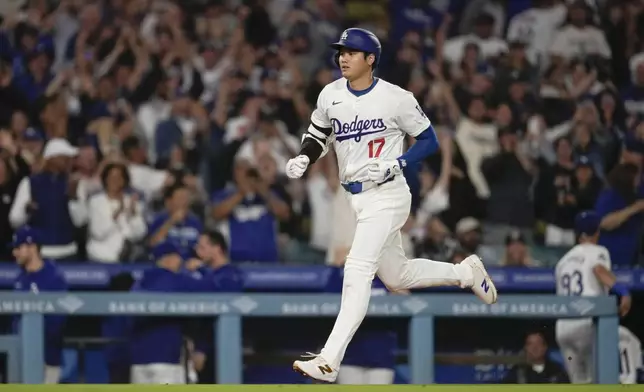 Los Angeles Dodgers designated hitter Shohei Ohtani (17) runs the bases after hitting a home run during the fifth inning of a baseball game against the Colorado Rockies in Los Angeles, Friday, Sept. 20, 2024. Max Muncy also scored. (AP Photo/Ashley Landis)