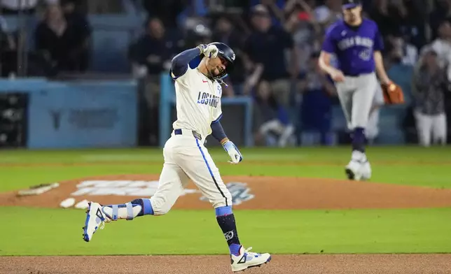 Los Angeles Dodgers' Mookie Betts (50) runs the bases after hitting a home run during the third inning of a baseball game against the Colorado Rockies in Los Angeles, Saturday, Sept. 21, 2024. Shohei Ohtani also scored. (AP Photo/Ashley Landis)