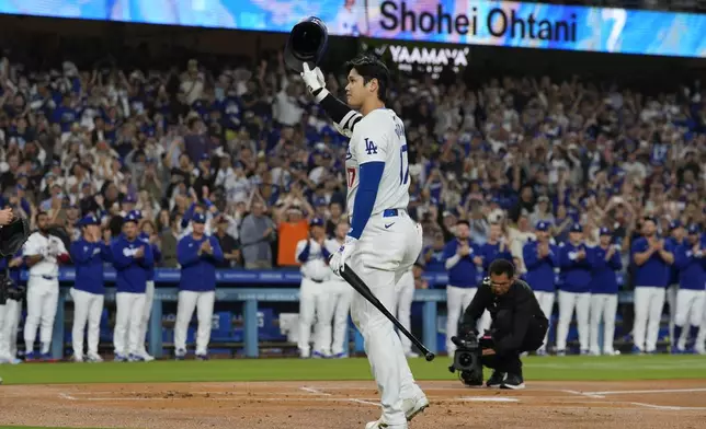 Los Angeles Dodgers designated hitter Shohei Ohtani (17) is honored during the first inning of a baseball game against the Colorado Rockies in Los Angeles, Friday, Sept. 20, 2024. Ohtani was the first MLB player to achieve 50 home runs and 50 stolen bases in a single season. (AP Photo/Ashley Landis)