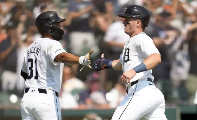 Detroit Tigers' Jace Jung, right, celebrates scoring with Riley Greene (31) against the Colorado Rockies in the fourth inning of a baseball game, Thursday, Sept. 12, 2024, in Detroit. (AP Photo/Paul Sancya)