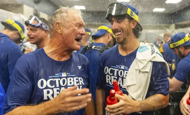 Hall of Fame Kansas City Royals' infielder George Brett, left, celebrates with pitcher Michael Lorenzen, right, in the locker room after a baseball game against the Atlanta Braves, Friday, Sept. 27, 2024, in Atlanta. (AP Photo/Jason Allen)