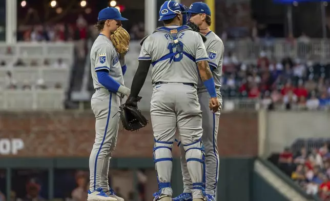 Kansas City Royals shortstop Bobby Witt Jr., left, pitcher Brady Singer, center, and catcher Salvador Perez, right, meet at the mound in the first inning of a baseball game against the Atlanta Braves, Friday, Sept. 27, 2024, in Atlanta. (AP Photo/Jason Allen)