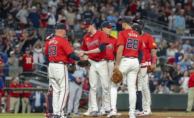 Atlanta Braves pitcher Max Fried, center, hands the ball to manager Brian Snitker (43) after being relieved in the ninth inning of a baseball game against the Kansas City Royals, Friday, Sept. 27, 2024, in Atlanta. (AP Photo/Jason Allen)