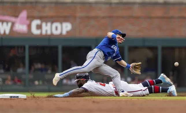 Atlanta Braves' Michael Harris II, bottom, slides successfully into second before Kansas City Royals second baseman Michael Massey, top, can catch the ball in the first inning of a baseball game, Sunday, Sept. 29, 2024, in Atlanta. (AP Photo/Jason Allen)