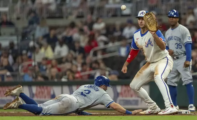 Kansas City Royals outfielder Garrett Hampson, left, slides into first base before Atlanta Braves first baseman Matt Olson, right, catches the ball in the eighth inning of a baseball game, Saturday, Sept. 28, 2024, in Atlanta. (AP Photo/Jason Allen)