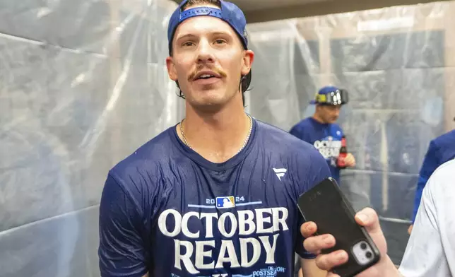 Kansas City Royals shortstop Bobby Witt Jr. speaks with a reporter during a celebration in the locker room after a baseball game against the Atlanta Braves, Friday, Sept. 27, 2024, in Atlanta. (AP Photo/Jason Allen)