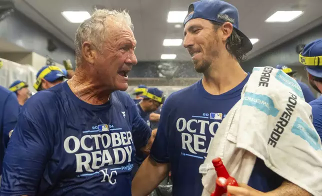 Hall of Fame Kansas City Royals infielder George Brett, left, congratulates pitcher Michael Lorenzen, right, during a celebration in the locker room after a baseball game against the Atlanta Braves, Friday, Sept. 27, 2024, in Atlanta. (AP Photo/Jason Allen)