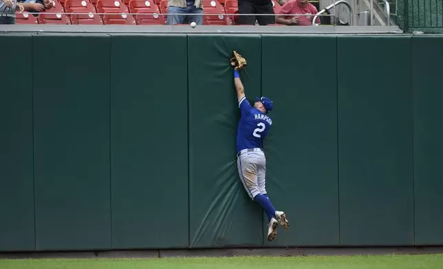 Kansas City Royals center fielder Garrett Hampson jumps for a ball that went for a three-run home run by Washington Nationals' Luis Garcia Jr. during the third inning of a baseball game, Thursday, Sept. 26, 2024, in Washington. (AP Photo/Nick Wass)