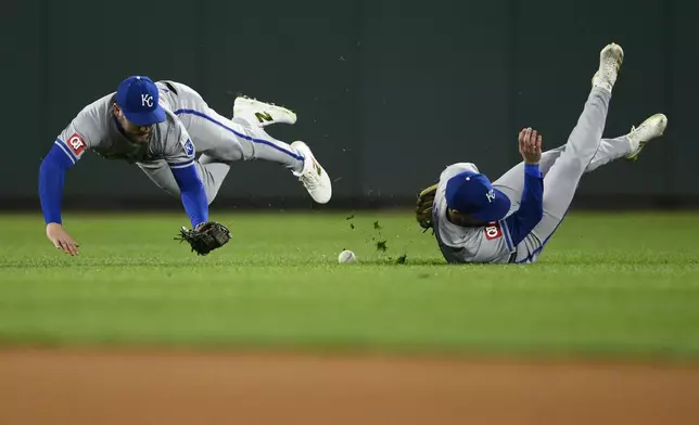 Kansas City Royals center fielder Kyle Isbel, left, and second baseman Michael Massey, right, tumble after they tried for a fly ball hit for a double by Washington Nationals' Jacob Young during the seventh inning of a baseball game, Tuesday, Sept. 24, 2024, in Washington. (AP Photo/Nick Wass)