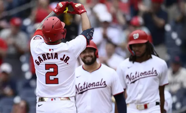 Washington Nationals' Luis Garcia Jr. (2) celebrates his three-run home run with Juan Yepez, center, and James Wood, right, during the third inning of a baseball game against the Kansas City Royals, Thursday, Sept. 26, 2024, in Washington. (AP Photo/Nick Wass)