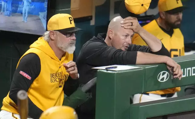 Pittsburgh Pirates manager Derek Shelton, left, and bench coach Don Kelly, center, stand in the dugout during the sixth inning of a baseball game against the Kansas City Royals in Pittsburgh, Friday, Sept. 13, 2024. (AP Photo/Gene J. Puskar)