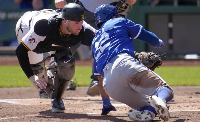 Pittsburgh Pirates catcher Joey Bart, left, tags out Kansas City Royals' Tommy Pham, right, who was attempting to score from third base on a flyout to right field by Bobby Witt Jr. during the third inning of a baseball game in Pittsburgh, Sunday, Sept. 15, 2024. (AP Photo/Gene J. Puskar)