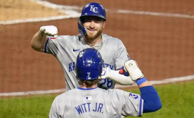 Kansas City Royals' Kyle Isbel, top, celebrates with Bobby Witt Jr. as he returns to the dugout after hitting a solo home run off Pittsburgh Pirates starting pitcher Luis L. Ortiz during the fourth inning of a baseball game in Pittsburgh, Friday, Sept. 13, 2024. (AP Photo/Gene J. Puskar)