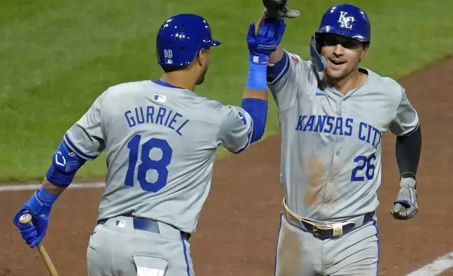 Kansas City Royals' Adam Frazier (26) celebrates with Yuli Gurriel as he crosses home plate after hitting a solo home run off Pittsburgh Pirates relief pitcher Kyle Nicolas during the eighth inning of a baseball game in Pittsburgh, Friday, Sept. 13, 2024. (AP Photo/Gene J. Puskar)