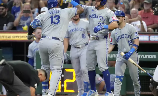 Kansas City Royals' Salvador Perez (13) celebrates with Tommy Pham as he heads to the dugout after hitting a two-run home run off Pittsburgh Pirates starting pitcher Luis L. Ortiz during the second inning of a baseball game in Pittsburgh, Friday, Sept. 13, 2024. The Royals won 8-3. (AP Photo/Gene J. Puskar)